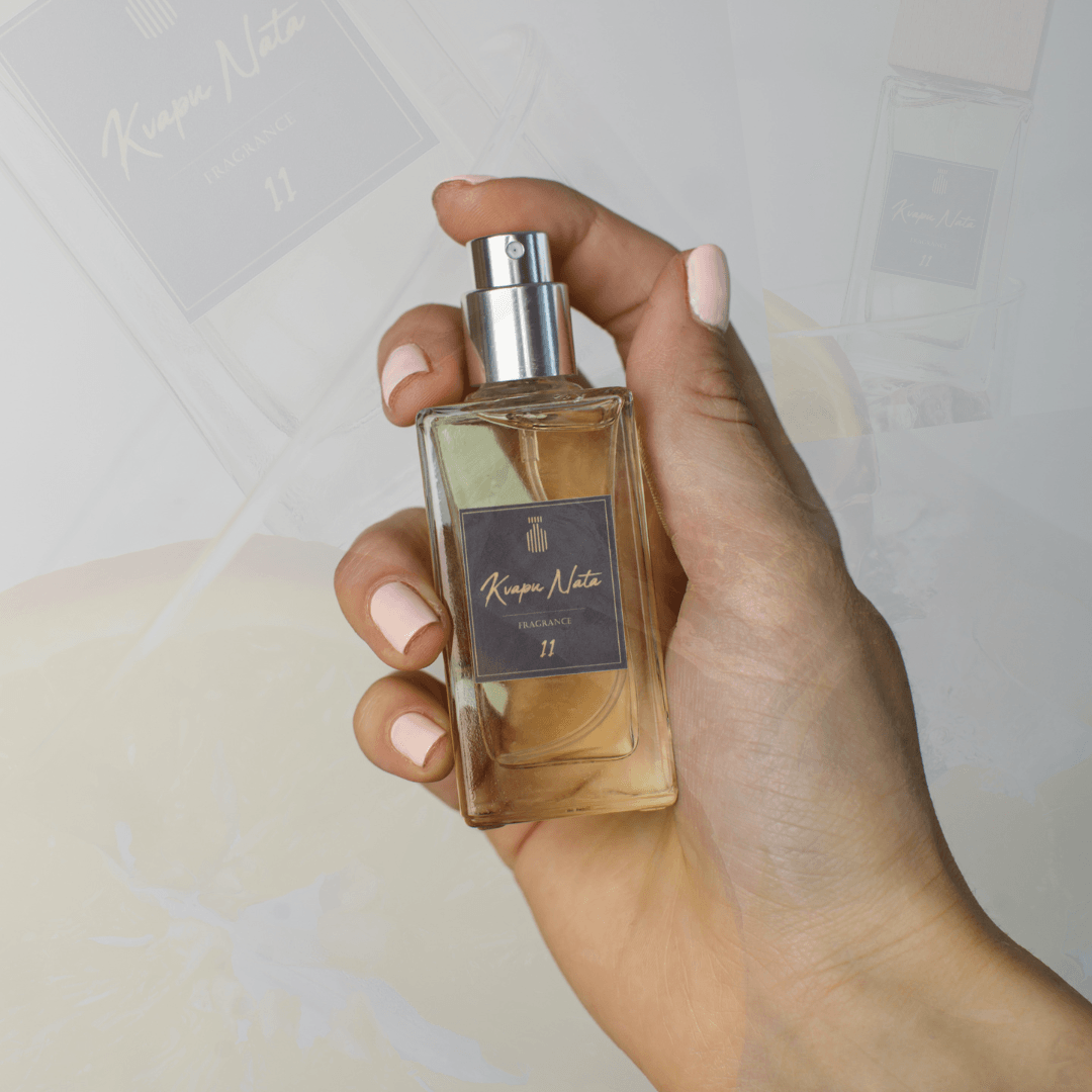 Hand holding a bottle of fragrance 11 from Kvepian Nata, showcasing elegant design and light-colored liquid.
